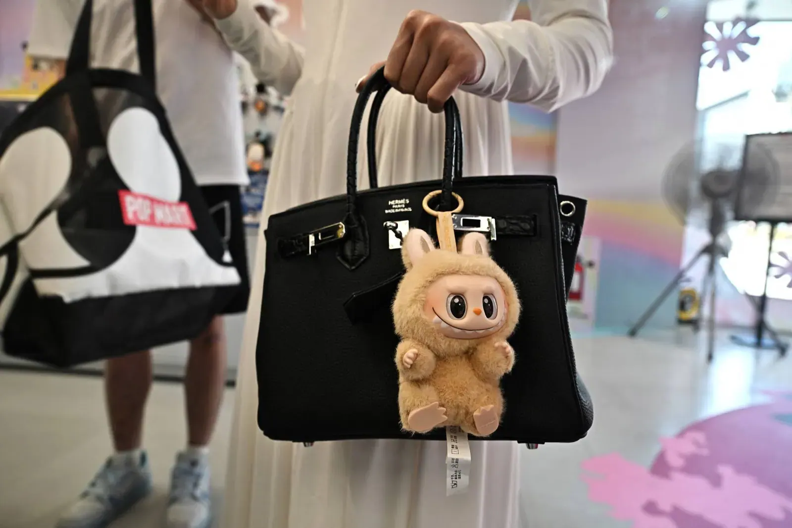 挂在购物者手袋上的 Labubu 毛绒挂件（图片来源：Getty Images）